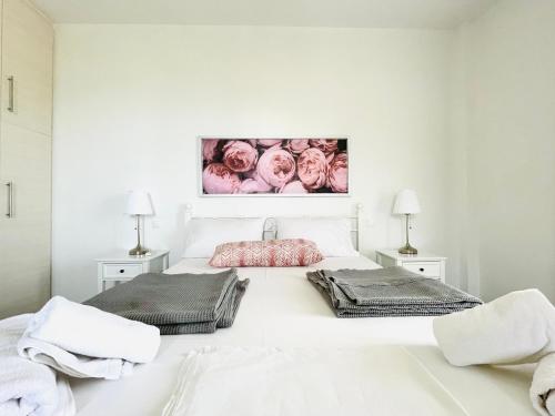 a white bedroom with two beds and two lamps at Aricobé in Ancient Epidauros