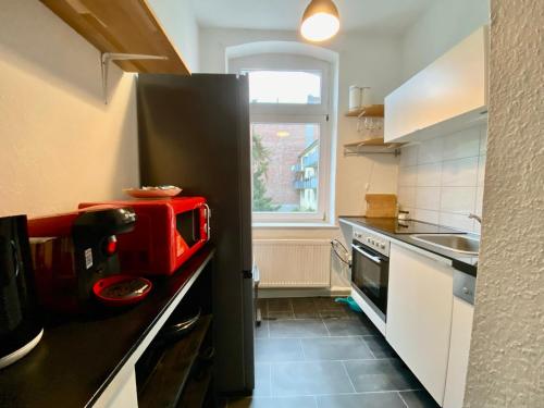 uma cozinha com um aparelho vermelho no balcão em Cil Apt.- Gemütliche Wohnung am Philosophenweg mit Netflix in zentraler & ruhiger Lage em Kassel