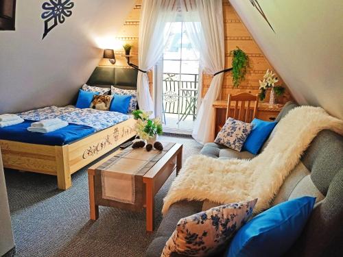 1 dormitorio con cama, sofá y mesa en Apartament - Willa Na Górskim Szlaku en Murzasichle