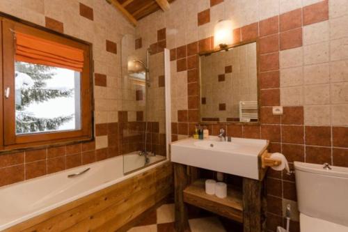 a bathroom with a sink and a tub and a mirror at Chalet privatif pour 8 personnes aux Coches - Paradiski in Les Coches