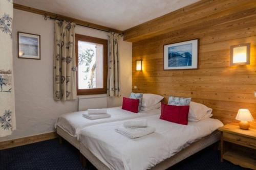 a bedroom with a large white bed with red pillows at Chalet privatif pour 8 personnes aux Coches - Paradiski in Les Coches
