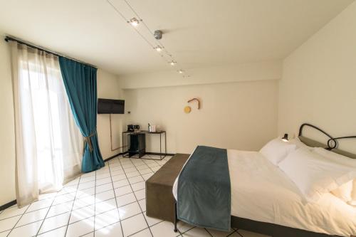 a bedroom with a bed and a blue curtain at Palazzo Sertorio Suites in Gavi