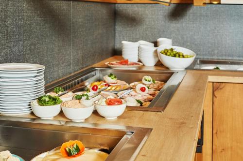 a buffet line with plates and bowls of food at Ruperti - Gästehaus in Ainring