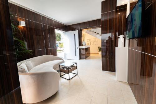 a lobby with a white chair and a table at Hotel Falli in Porto Cesareo