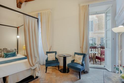 a room with a bed and two chairs and a table at Relais Giulia in Rome