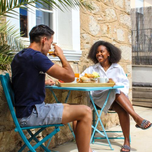 a man and a woman sitting at a table eating food at B&B Villa Du Roc Fleuri in Cannes