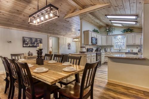 a kitchen and dining room with a wooden table and chairs at Whispering Winds in Gatlinburg