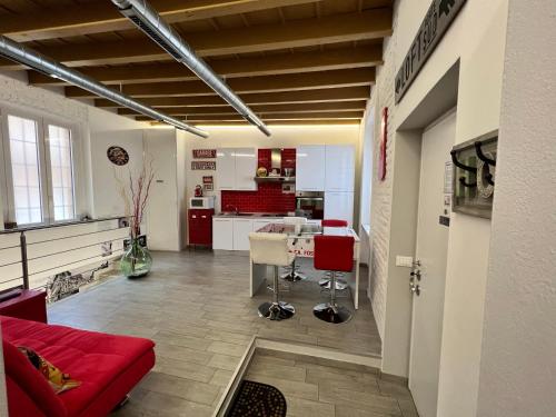 CA FOSCARI Loft & Factory في ميلانو: غرفة معيشة مع أريكة حمراء ومطبخ