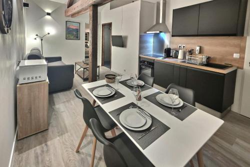 eine Küche mit einem Tisch und Stühlen im Zimmer in der Unterkunft Superbe, T2 élégant, Neuf, Parking in Gerde