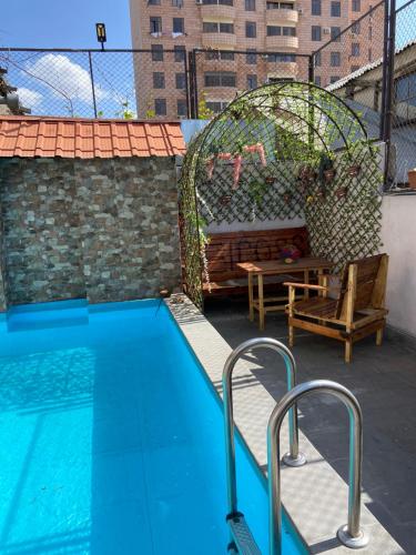 a swimming pool with a gazebo and a bench at Elross Hotel in Yerevan