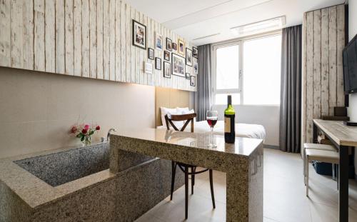 a hotel room with a bottle of wine on a counter at Hotel The Designers Hongdae in Seoul