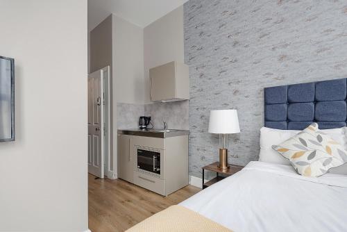 倫敦的住宿－Modern Studio Apartments，一间卧室配有一张特大号床和一个壁炉