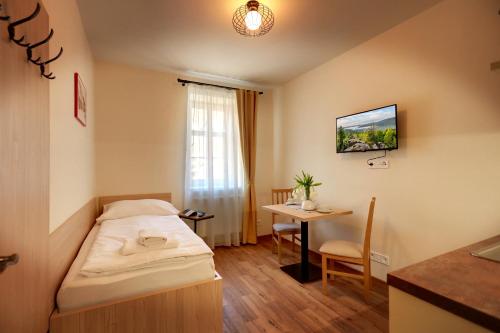 mały pokój z łóżkiem i stołem w obiekcie Apartmány Tatra w mieście Jáchymov