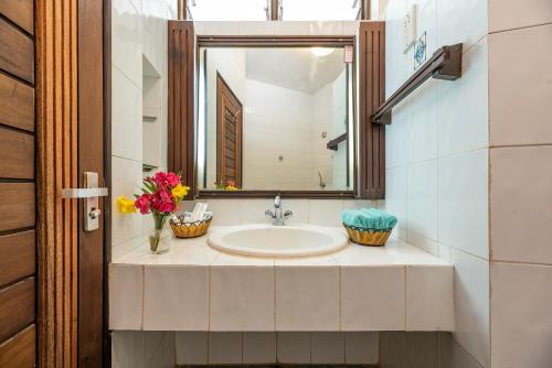 ein Bad mit einem Waschbecken und einem Spiegel in der Unterkunft Safari Beach Hotel in Diani Beach