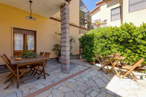 a patio with a table and chairs and a pillar at Paolo e Francesca in Bosa Marina