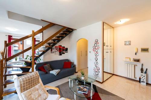 a living room with a blue couch and a staircase at Tresa Bay House - Lugano Lake in Lavena Ponte Tresa