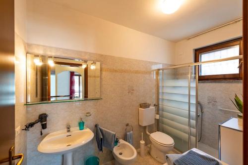 a bathroom with a sink and a toilet and a mirror at Tresa Bay House - Lugano Lake in Lavena Ponte Tresa
