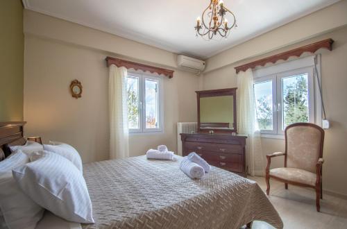 1 dormitorio con cama, espejo y silla en Villa Vrisi en Fayiás