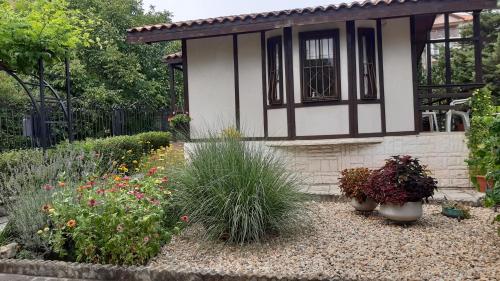 un jardín con flores y plantas frente a una casa en Motivi cottage en St. St. Constantine and Helena