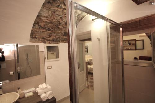 a bathroom with a shower and a sink and a mirror at Historic house by the lake La Renée Casa Vacanza in Predore