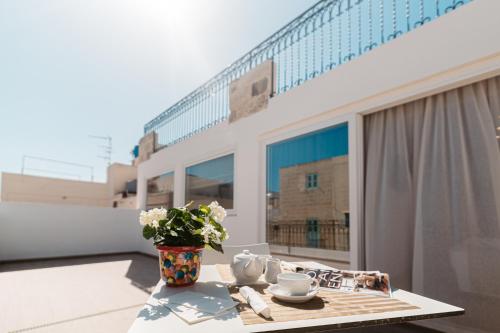 une table sur un balcon avec un vase de fleurs dans l'établissement Palazzo Violetta Boutique Hotel, à Sliema