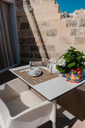 a table with a vase of flowers on top of it at Palazzo Violetta in Sliema