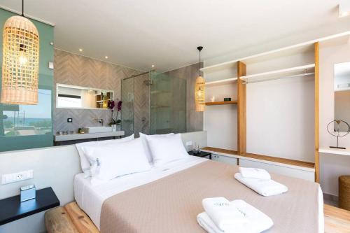 a bedroom with a large bed with two towels at Villa Daphne-Naiades/ 2 bedrooms,luxury,beachfront in Plakias