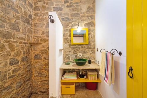 a bathroom with a sink and a stone wall at Algarve Charming Rural 1br Villa in Santa Bárbara de Nexe