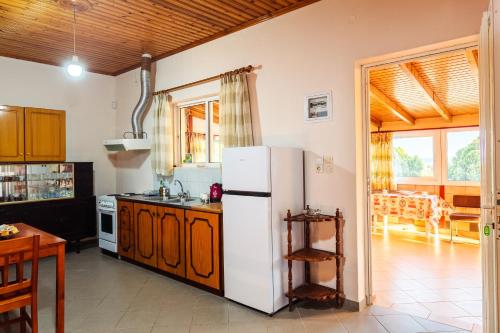 a kitchen with a white refrigerator and a table at Makarounis Athanasios Traditional Apartments(Ξενώνας) in Petalidhion