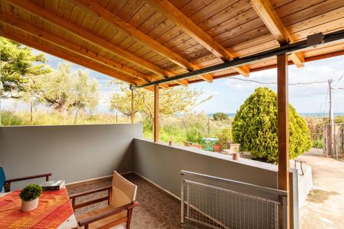 a patio with a wooden pergola and a table at Makarounis Athanasios Traditional Apartments(Ξενώνας) in Petalidhion