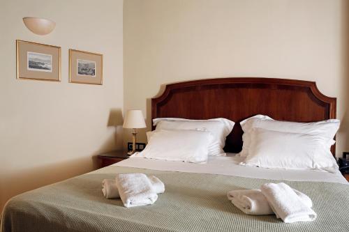 a bedroom with a bed with towels on it at Siora Vittoria Boutique Hotel in Corfu Town