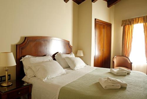 a bedroom with a large bed with two towels on it at Siora Vittoria Boutique Hotel in Corfu Town