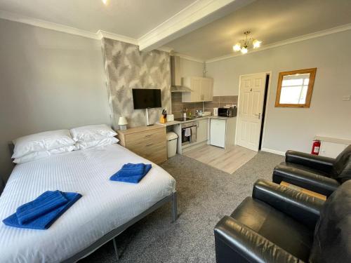 a bedroom with a bed and a couch and a kitchen at Large Ground Floor Studio Holiday Apartment Skegness - Flat 12 in Skegness