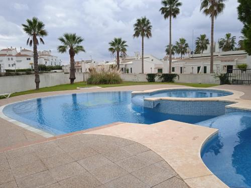 a swimming pool in a yard with palm trees at Cala´n Bosch in Cala en Bosc