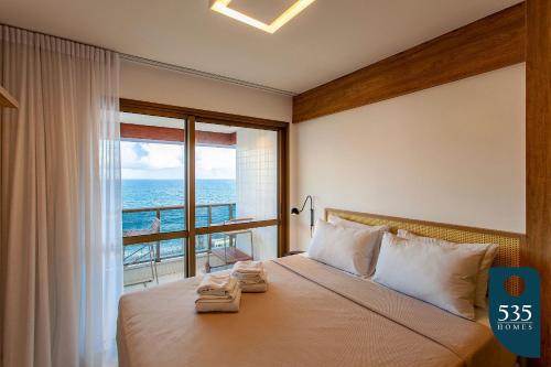 a bedroom with a bed with a view of the ocean at BARRA Vista Mar Lindo apartamento, Wi-Fi 300Mbps in Salvador
