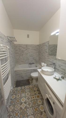 a bathroom with a sink and a toilet and a tub at Résidence Le Bonaparte in Roquebrune-Cap-Martin