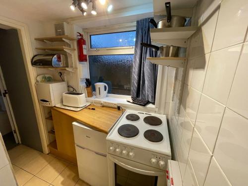 a small kitchen with a stove and a window at 1 Bedroom Ground Floor Holiday Apartment Skegness - Flat 11 in Skegness