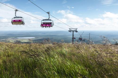 three gondolas on a ski lift over a hill at Ski-Inn PyhäSuites in Pyhätunturi