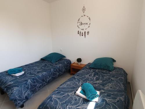 two beds sitting next to each other in a room at GITE COTE LAC in Valréas