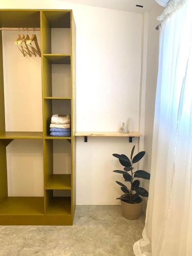 ein Schrank mit gelben Regalen und einer Pflanze in einem Zimmer in der Unterkunft Al Manor Bed & Breakfast in Dalaya