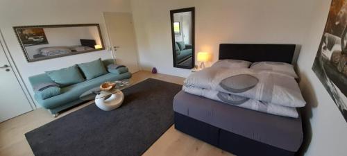 a bedroom with a large bed and a couch at My Sweet Home City in Düsseldorf