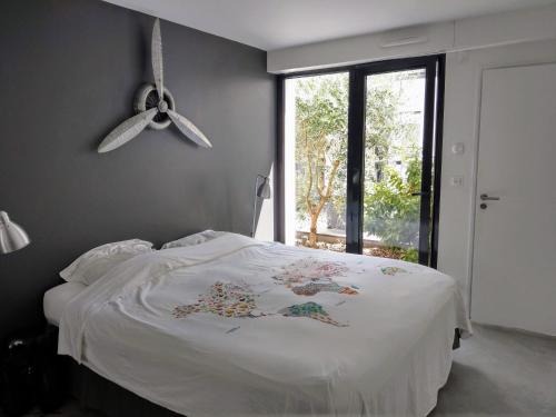 Schlafzimmer mit einem Bett mit weißer Bettwäsche und einem Fenster in der Unterkunft Rouen centre avec Sauna - Jacuzzi - Parking - 5 étoiles in Rouen