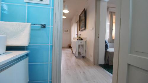 a bathroom with a blue tiled wall and a sink at Grecalotto Apartment in La Maddalena