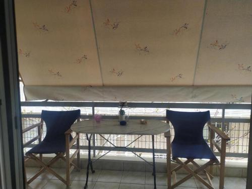 a table and two chairs in front of a window at Small and cosy appartment- Piccolina in Loutraki