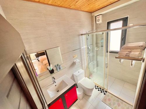 a bathroom with a toilet and a shower and a sink at INg Hostel in Hualien City