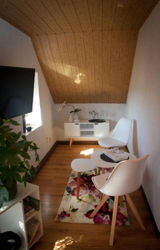 a living room with two chairs and a table and a tv at Gästezimmer im Grünen Haus in Thum