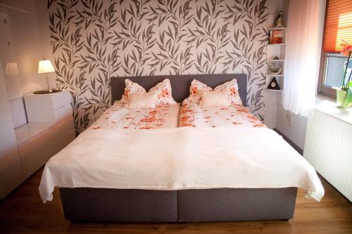 a bedroom with a bed with white sheets and pink pillows at Gästezimmer im Grünen Haus in Thum