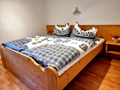 a bed with black and white pillows on it at Chalet Waldheim in Zell am Ziller