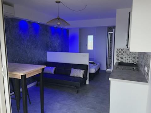 a blue living room with a couch and a table at Cyllène Port Nature 5 in Cap d'Agde