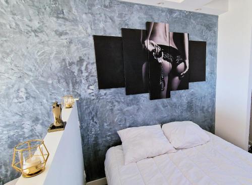 a bedroom with a bed and a painting on the wall at Cyllène Port Nature 5 in Cap d'Agde